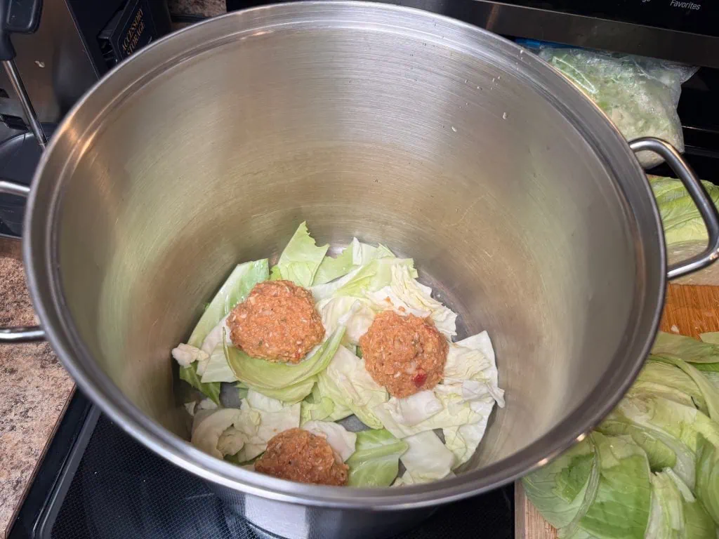 Layering the cabbage and meatballs